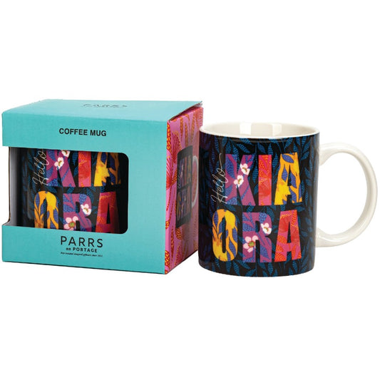 Colorful coffee mug with 'Mia Cara' design next to its packaging on a white background